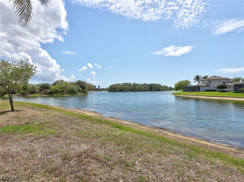 6422 Legacy Circle, Unit 704 Naples, FL 34113 - Photo 39 of 49 a view of a lake with houses in the back