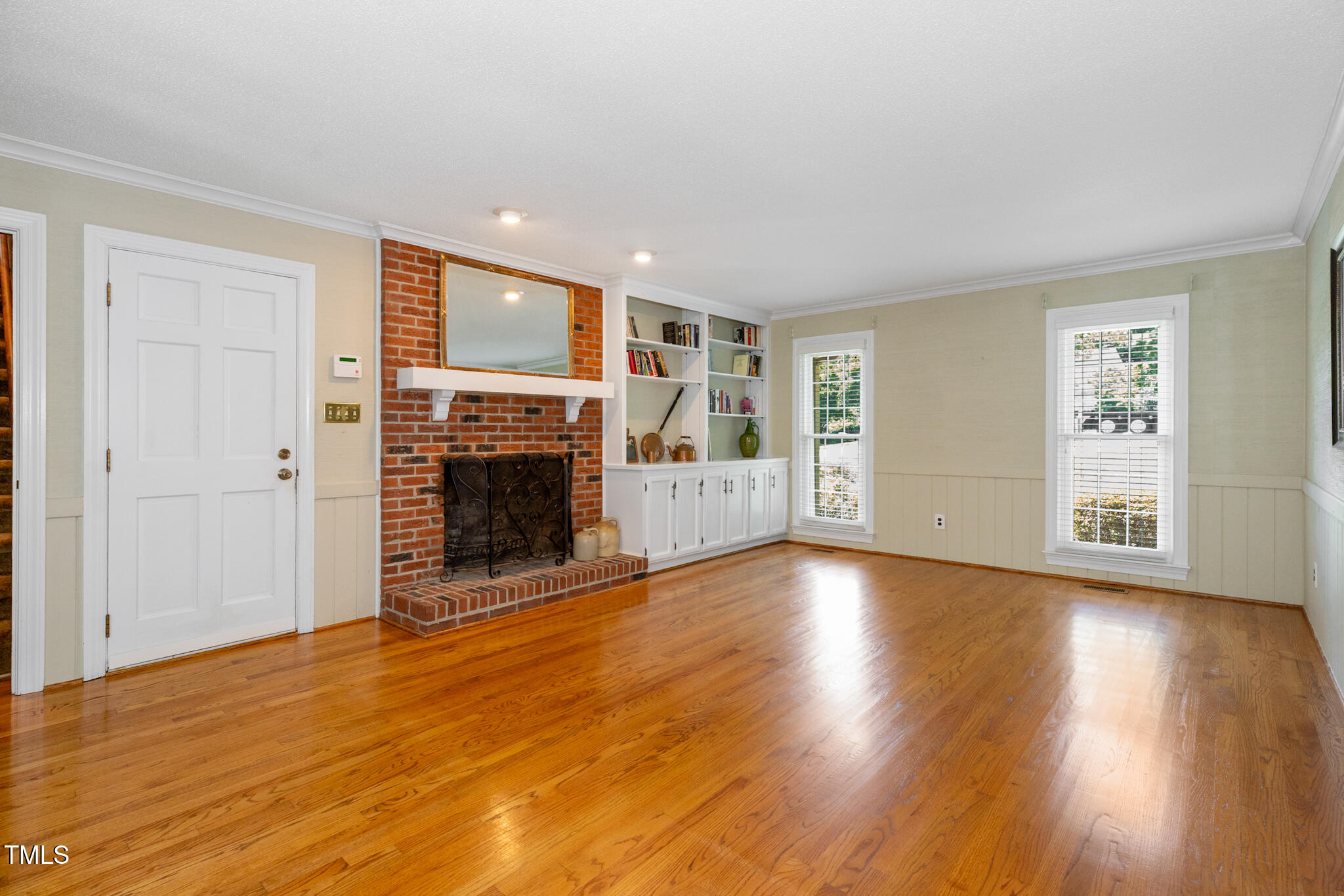 6904 Aspen Court Raleigh, NC 27615 - Photo 22 of 51 an empty room with wooden floor fireplace and windows