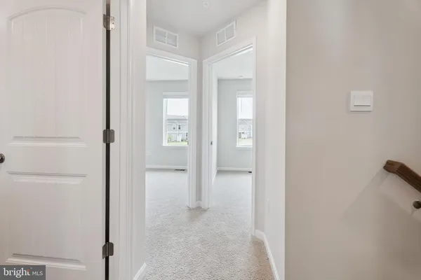 a view of an empty room with closet and a window