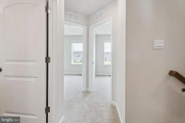 a view of an empty room with closet and a window