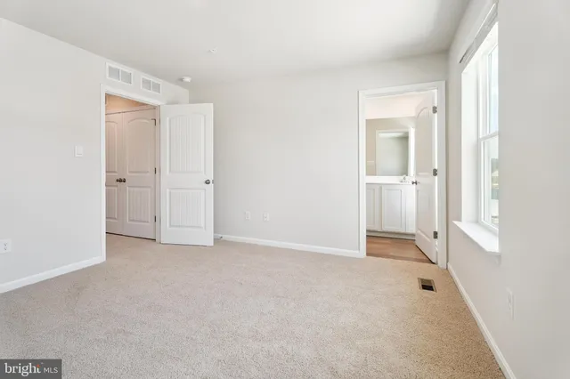 a bathroom with a toilet a sink a mirror and a window