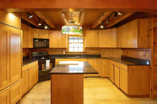 a kitchen with stainless steel appliances kitchen island granite countertop a sink and cabinets
