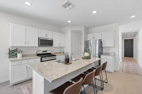 a kitchen with stainless steel appliances kitchen island granite countertop a sink and cabinets