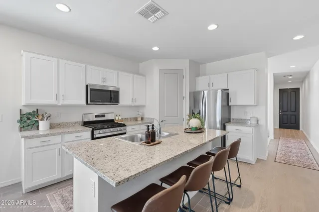 a kitchen with stainless steel appliances kitchen island granite countertop a sink and cabinets