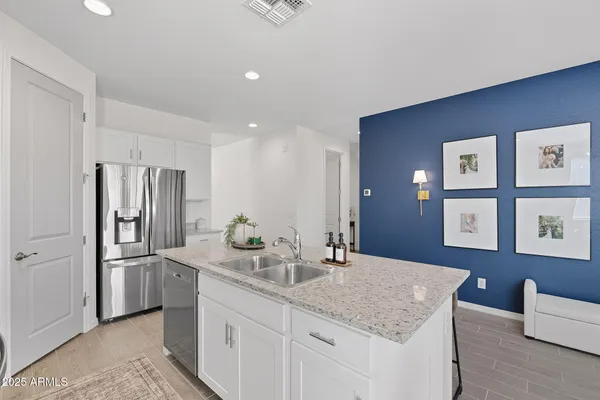 a kitchen with stainless steel appliances granite countertop a sink refrigerator and cabinets
