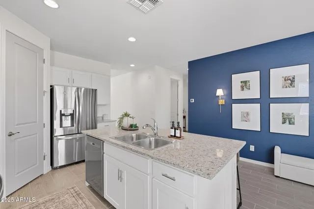 a kitchen with stainless steel appliances granite countertop a sink refrigerator and cabinets
