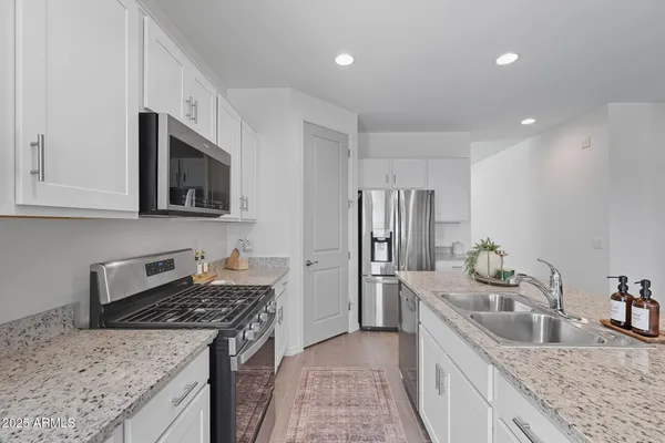 a kitchen with stainless steel appliances granite countertop a sink stove and refrigerator