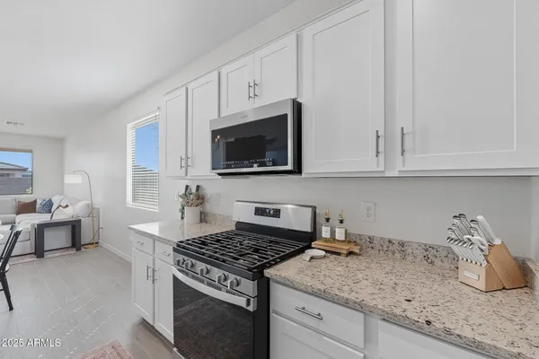 a kitchen with granite countertop a sink stove and cabinets