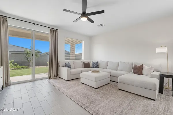 a living room with furniture and a floor to ceiling window