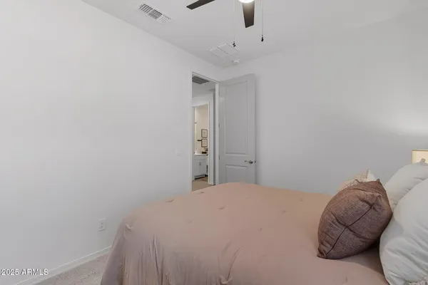 a bedroom with a bed and a ceiling fan