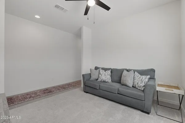 a living room with furniture and a ceiling fan