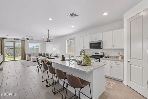 a kitchen with a table chairs microwave and cabinets