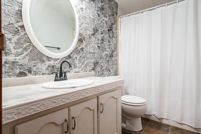 a bathroom with a granite countertop sink and a mirror