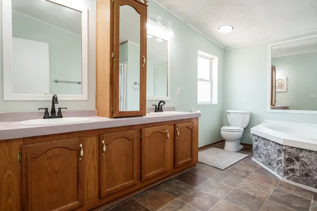 a spacious bathroom with a double vanity sink a mirror and a bathtub