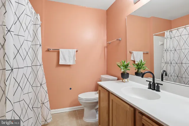 a bathroom with a granite countertop sink and a toilet