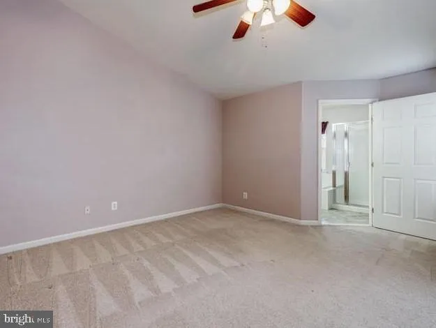an empty room with chandelier fan