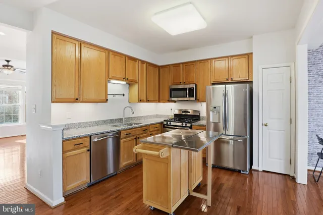 a kitchen with wooden cabinets and stainless steel appliances