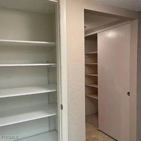 a view of walk in closet with empty racks