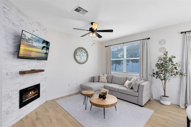 a living room with furniture a chandelier and a fireplace