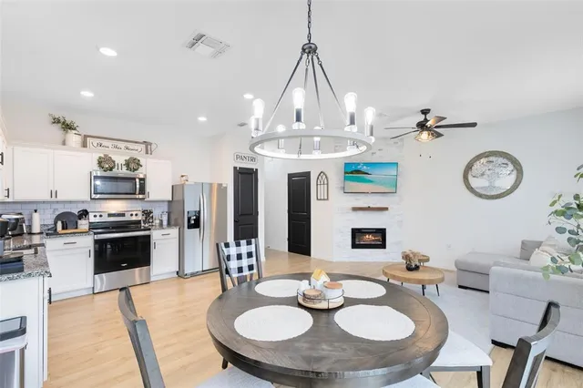 a dining room with furniture a kitchen and chandelier