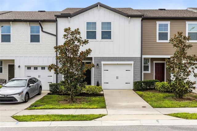 a front view of a house with a garden and trees