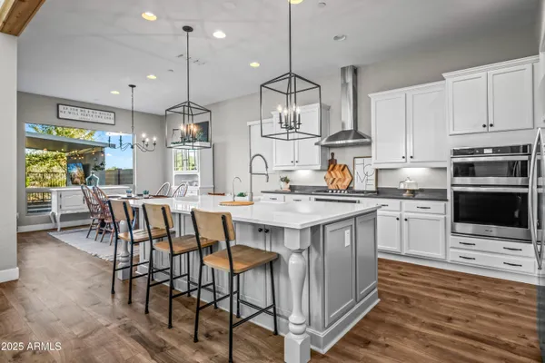 a kitchen with stainless steel appliances granite countertop a kitchen island a stove a table and chairs in it