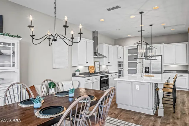 a kitchen with stainless steel appliances granite countertop a stove a sink dishwasher and cabinets with wooden floor