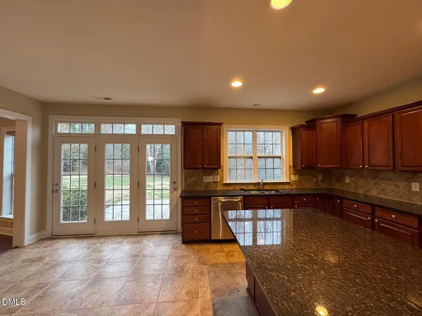 a large kitchen with kitchen island granite countertop a large window