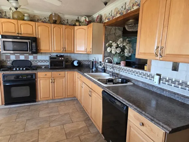 a kitchen with a sink stove top oven and cabinets