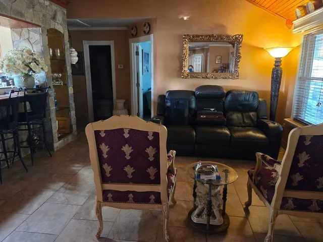 a living room with furniture a wooden floor and a sink