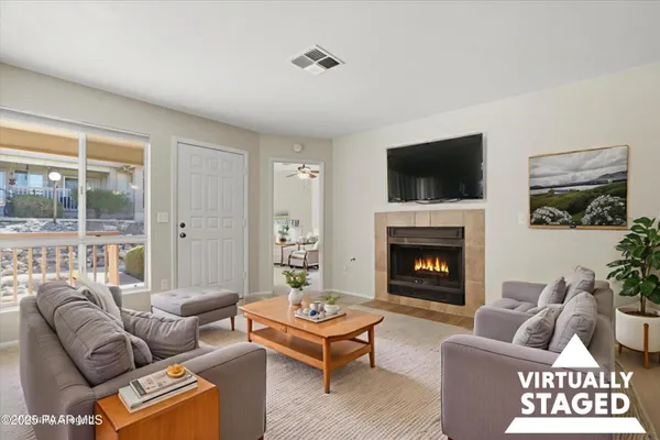 a living room with furniture a flat screen tv and a fireplace