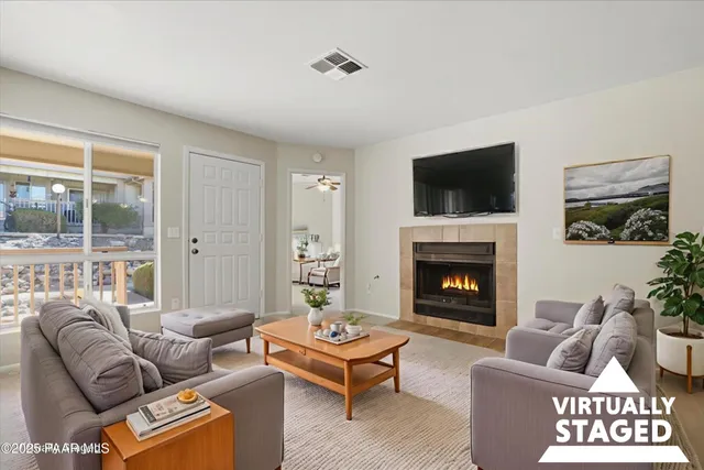 a living room with furniture a flat screen tv and a fireplace
