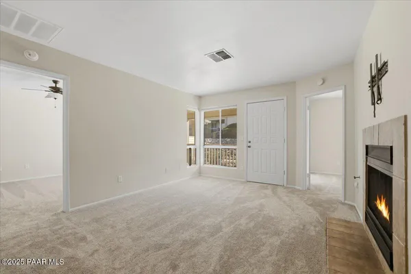a view of an empty room with a fireplace and a window