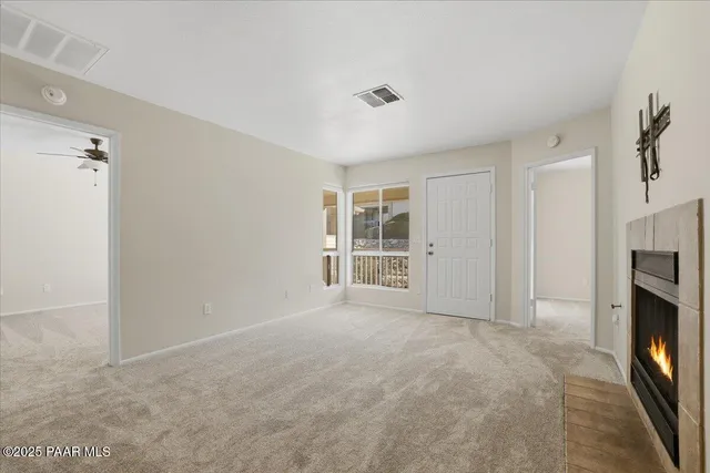 a view of an empty room with a fireplace and a window