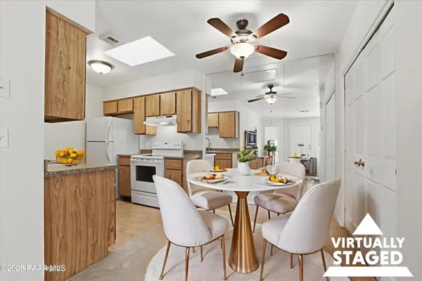 a view of a dining room and a kitchen with a table chairs