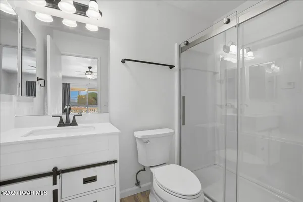a bathroom with a sink a toilet a mirror and shower