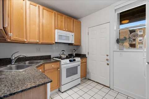 a kitchen with granite countertop a sink stove and cabinets