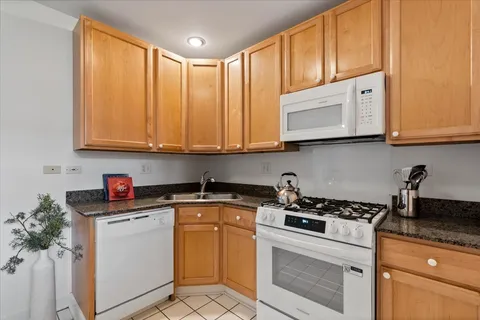 a kitchen with granite countertop cabinets stainless steel appliances and a sink
