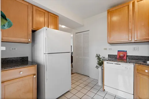 a kitchen with a refrigerator sink and cabinets