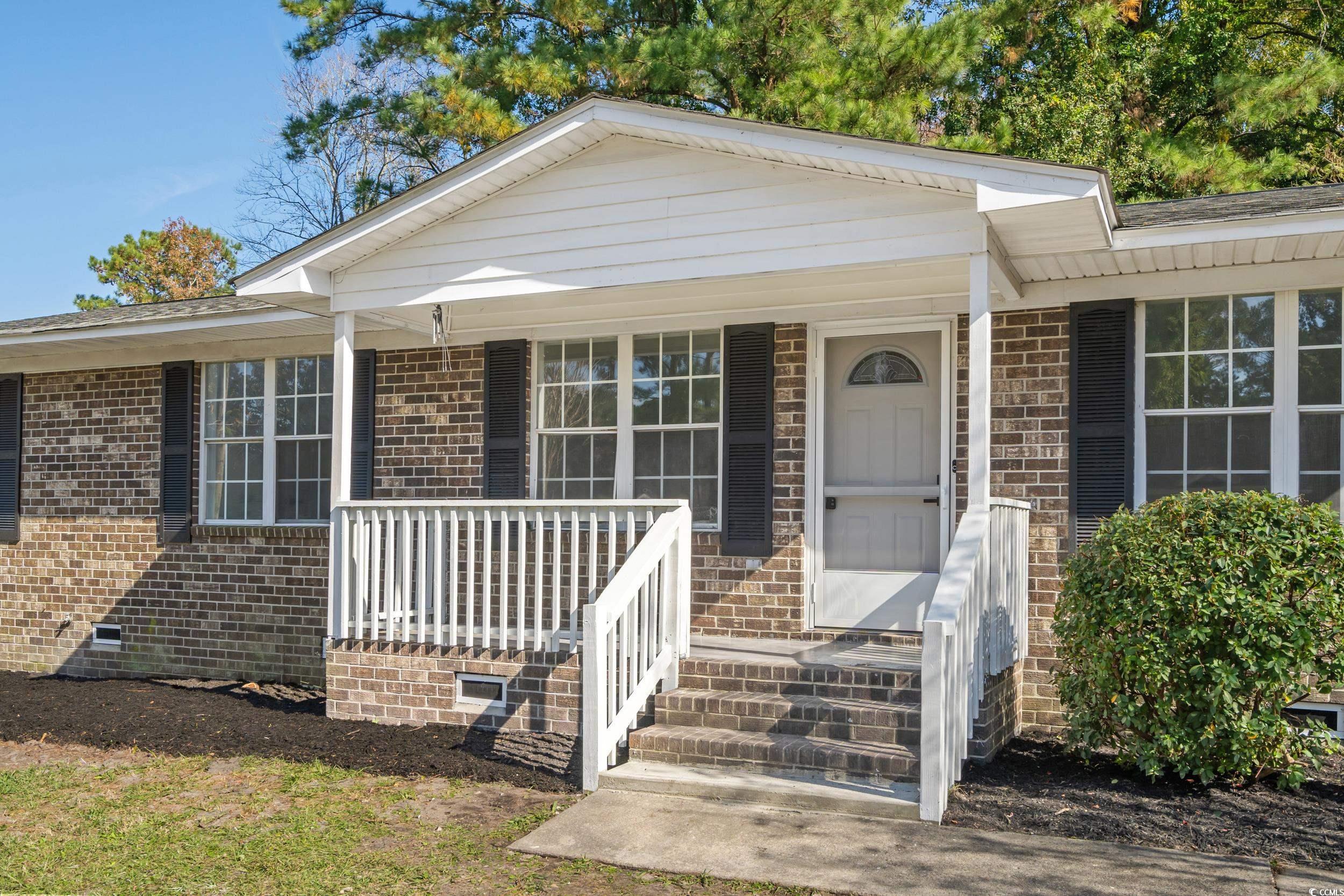 View of front of house featuring crawl space, covered porch, and brick siding