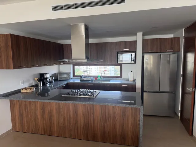 a kitchen with stainless steel appliances granite countertop a refrigerator a sink and a stove