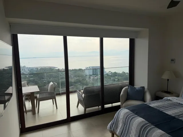 a view of a bedroom with furniture and floor to ceiling window