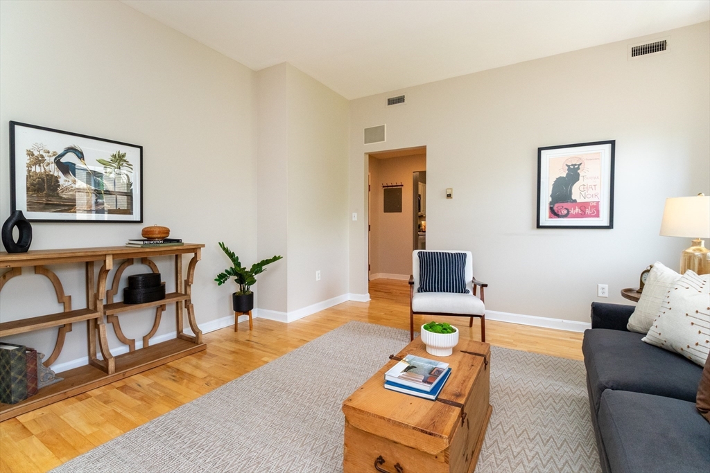 60e Glen Road, Unit 306 Brookline, MA 02445 - Photo 10 of 27 a living room with furniture and paintings on the wall