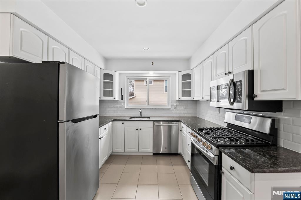 a kitchen with stainless steel appliances granite countertop a refrigerator stove and sink
