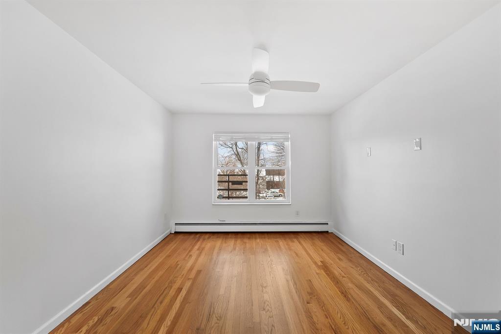 198 Conover Avenue, Unit 4 Nutley, NJ 07110 - Photo 11 of 17 an empty room with a window and wooden floor