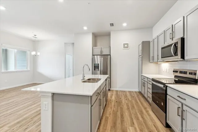 a kitchen with stainless steel appliances granite countertop a sink stove and refrigerator