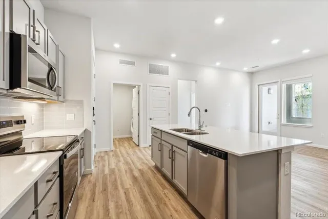 a kitchen with stainless steel appliances granite countertop a sink stove and refrigerator