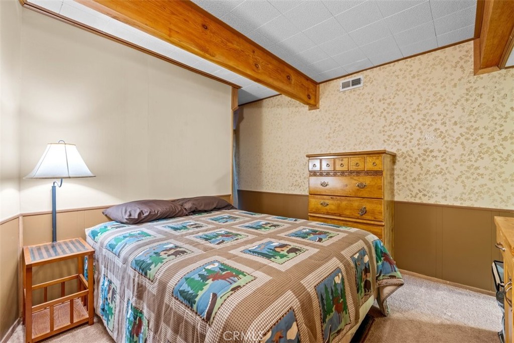 26305 Jacqueline Road Twin Peaks, CA 92391 - Photo 14 of 33 a bedroom with a bed and a lamp on the wall