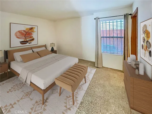 a bedroom with a bed and a painting on the wall