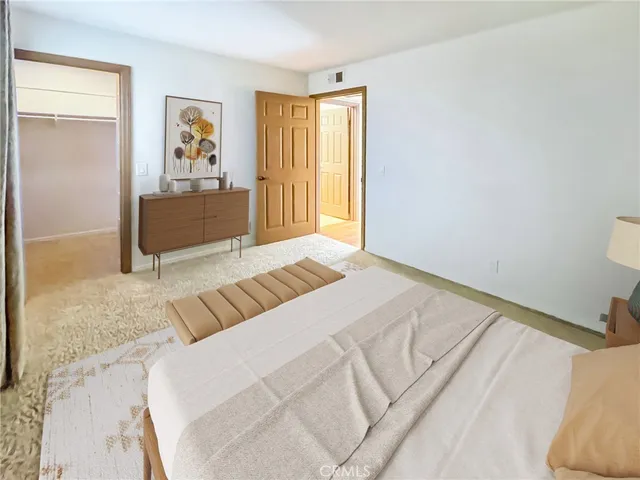 a bedroom with a bed and painting on the wall